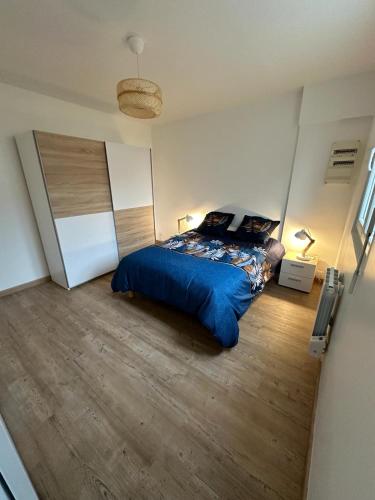 Schlafzimmer mit einem Bett mit blauer Decke in der Unterkunft Maison de ville in Concarneau