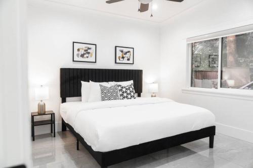 een witte slaapkamer met een groot bed en een raam bij Spacious Luxury Home With Amazing Views in Surrey