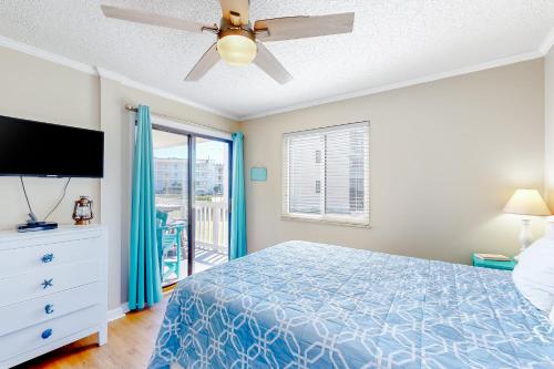 a bedroom with a bed and a ceiling fan at Ocean Breeze 106B in Emerald Isle