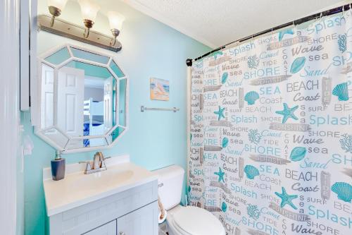 a bathroom with a toilet and a shower curtain at Ocean Breeze 106B in Emerald Isle