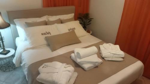 Una cama blanca con toallas encima. en Paradise Beach House, en Flámbouras