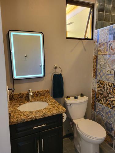 a bathroom with a sink and a toilet and a mirror at Hacienda en Los Volcanes in Hacienda Guayabo