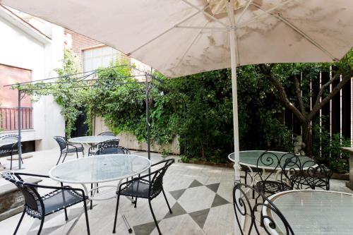 a patio with tables and chairs with an umbrella at Hotel Letizia in Orte