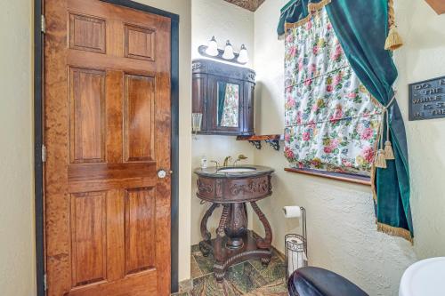 a bathroom with a sink and a wooden door at Cozy Kenai Abode with Private Deck 5 Mi to Ocean! in Kenai