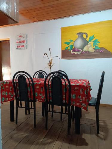 uma mesa com quatro cadeiras e uma mesa com uma toalha de mesa vermelha em Casa Mágica a orillas del Rio em Puerto Iguazú