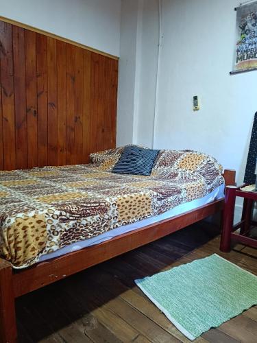 uma cama num quarto com uma colcha com estampa de chita em Casa Mágica a orillas del Rio em Puerto Iguazú