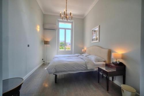 um quarto com uma cama, uma mesa e uma janela em Luxury 2-floor Flat (95 sqm) near Hotel Martinez em Cannes