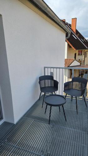 drie stoelen en een tafel op een balkon bij FeWo AS 5 Two Bamberg in Hallstadt