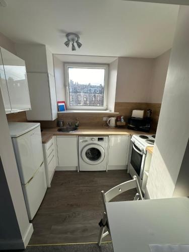a small kitchen with a washing machine and a window at Scott Street Modern Flat in Galashiels
