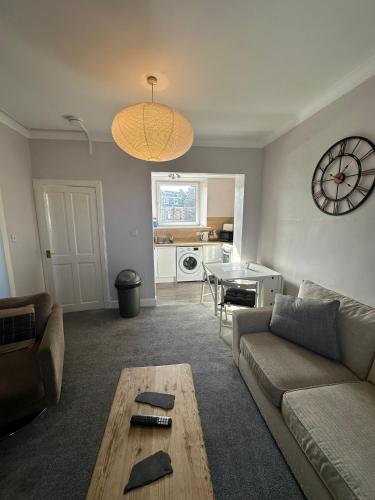 a living room with a couch and a table at Scott Street Modern Flat in Galashiels