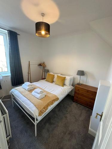 a bedroom with a bed with yellow pillows at Scott Street Modern Flat in Galashiels