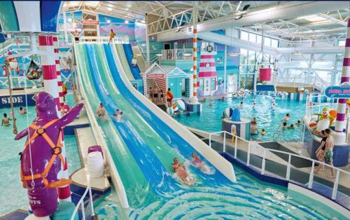 プスヘリにあるHafan Y Mor 5 Lakeside , 3 Bedrrom Deluxe sleeps 8の屋内スイミングプール(ウォータースライダー付)