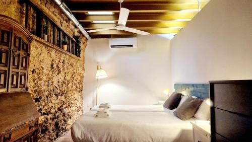 1 dormitorio con cama y pared de piedra en Homelike Malasaña, en Madrid