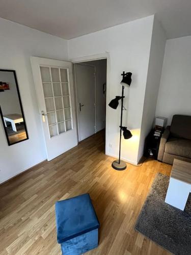 - un salon avec un canapé et une ottomane bleue dans l'établissement Appartement / Studio avec Balcon, à Bougival