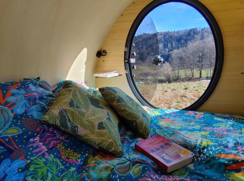 a bedroom with a bed with a window at Monchateau étoilé, hébergement insolite avec Spa in Merlas