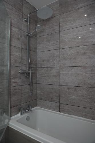 a bathroom with a shower and a bath tub at Modern and Comfy in City Centre PS4 , Free Parking ,Walking Distance To Bus, Train Stations And Shopping Centres in Leicester