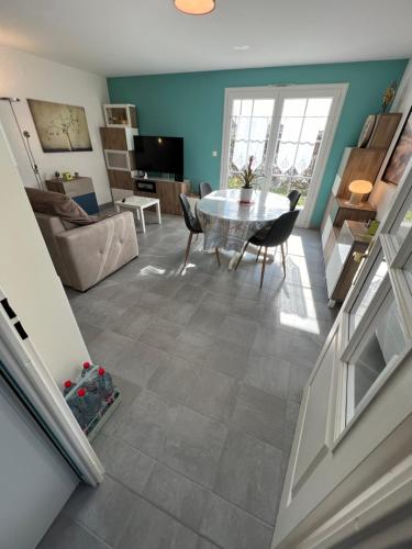une cuisine et un salon avec une table et des chaises dans l'établissement Maison Ariana 6 personnes à 5 min de la mer, au Crotoy