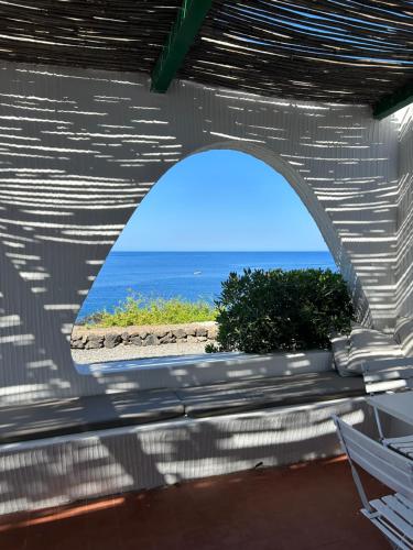 a view of the ocean through an arch in a building at Punta Tre Pietre 37 - Vista Tramonto in Scauri