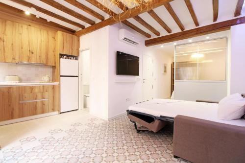 a bedroom with a large bed and a kitchen at Piso con encanto en la playa in Villajoyosa