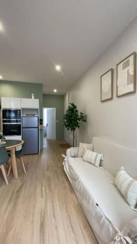 un salon avec un canapé blanc et une cuisine dans l'établissement Joli appartement avec parking - proche centre ville, à Chartres