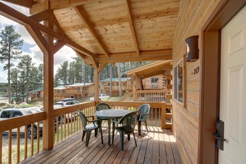 a wooden deck with a table and chairs on it at Rock Crest Lodge & Cabins in Custer