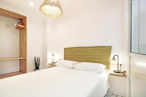 a white bedroom with a large white bed at Piso con encanto en la playa in Villajoyosa