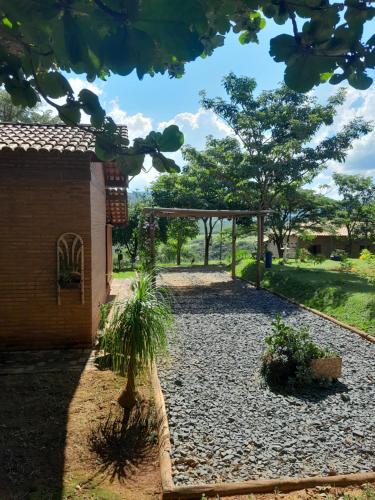 a garden with a pavilion and trees in the background at Chales Recanto das Seriemas in São Roque de Minas