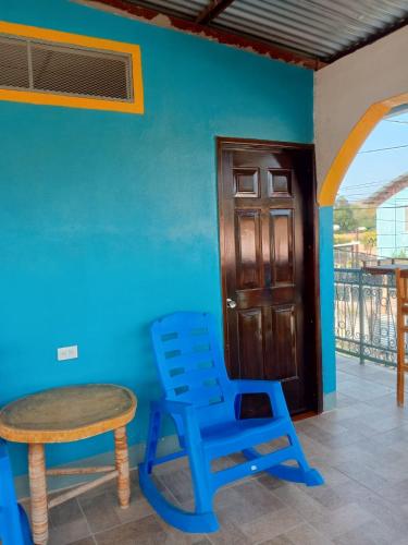 a blue room with a table and a blue chair at Hostal Siero in Moyogalpa