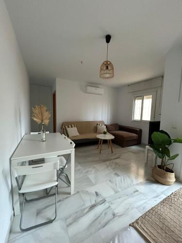 uma sala de estar com uma mesa branca e um sofá em Apartamento Ve&Va em Torre del Mar