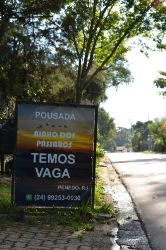 a sign on the side of a road at Ninho dos Passaros Penedo RJ in Penedo