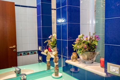 Baño de azulejos azules con flores en un lavabo en B&B CHIETI " Il SOGNO DI ARIS", en Chieti