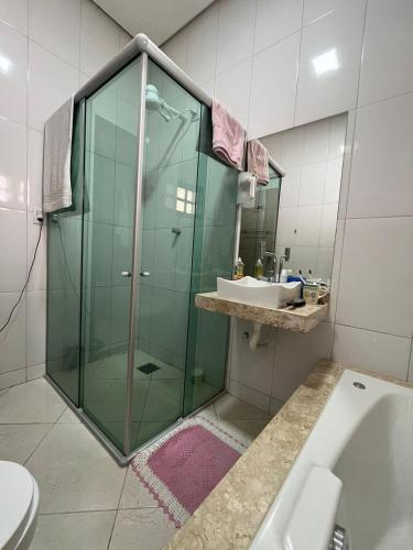 a bathroom with a glass shower and a sink at Casa Confort in Juazeiro do Norte