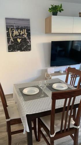 a dining room table with two chairs and a table with wine glasses at Somo&Pet Apartamento a 300 metros de la playa. in Somo