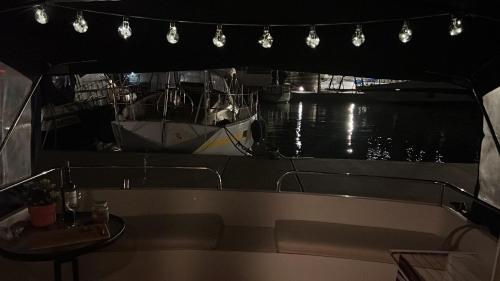 a boat in a harbor with a table and lights at Cosy and Homey Houseboat Castelldefels in Barcelona