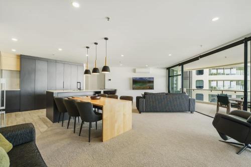 a kitchen and living room with a table and chairs at Oceanstyle on Main in Mount Maunganui