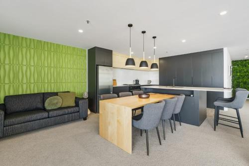 a kitchen and living room with a table and a couch at Oceanstyle on Main in Mount Maunganui