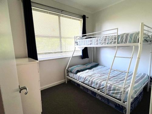 a bedroom with two bunk beds and a window at Beachcomber - 39 Phillip Drive South West Rocks in South West Rocks
