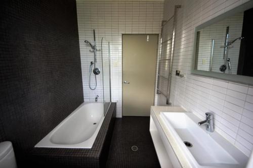 a bathroom with a white tub and a sink at Beachcomber - 39 Phillip Drive South West Rocks in South West Rocks