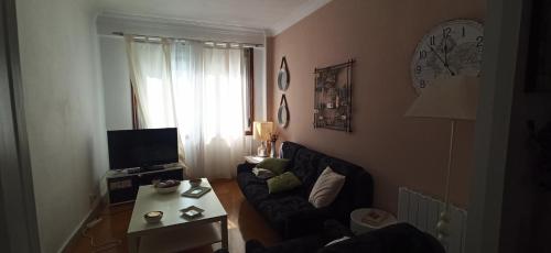 ein Wohnzimmer mit einem Sofa und einem Tisch in der Unterkunft El ensanche in Ferrol