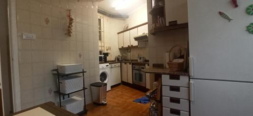 uma cozinha com um frigorífico e uma máquina de lavar e secar roupa em El ensanche em Ferrol