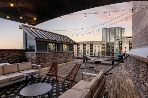 a rooftop deck with a couch and chairs on a building at Hotel Residential of Denver in Denver