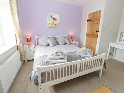 a bedroom with a white bed with towels on it at 1 Countryman Inn Cottages in Hunton