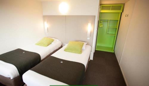 two beds in a small room with green doors at Downtown in Cairo