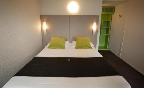 een slaapkamer met een groot bed met groene kussens bij Downtown in Caïro