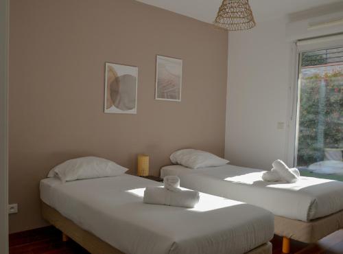 une chambre avec deux lits avec des serviettes dessus dans l'établissement Superbe 3 Pièces Jardin Piscine Nice, à Nice