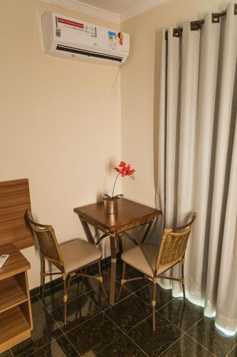 a room with a table and two chairs and a heater at VILLAGE GOLDEN HOTEL in Jales