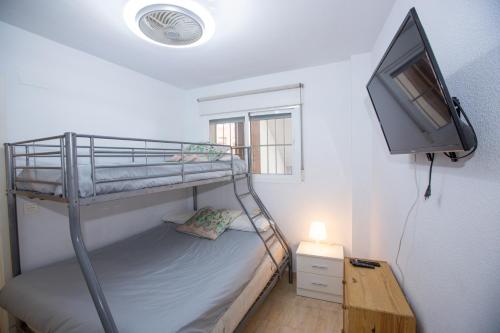 ein Schlafzimmer mit einem Etagenbett und einem Flachbild-TV in der Unterkunft ESPECTACULAR PISO EN LA HERRADURA, con parking gratis en julio y agosto in La Herradura