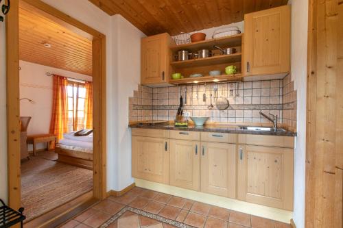 a kitchen with wooden cabinets and a sink at Landhaus Am Arzbach in Bad Tölz