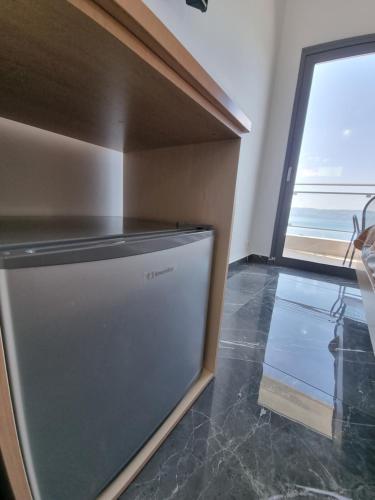 a refrigerator in a kitchen with a window at Porto Evia Boutique Hotel in Amarinthos