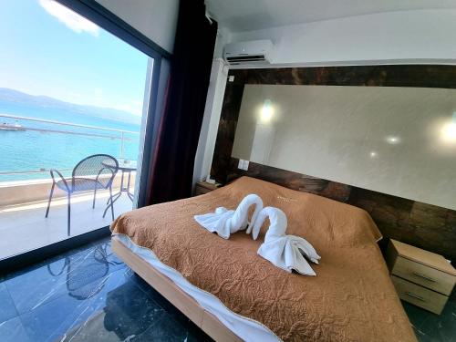 two swans towels on a bed in a room with a window at Porto Evia Boutique Hotel in Amarinthos